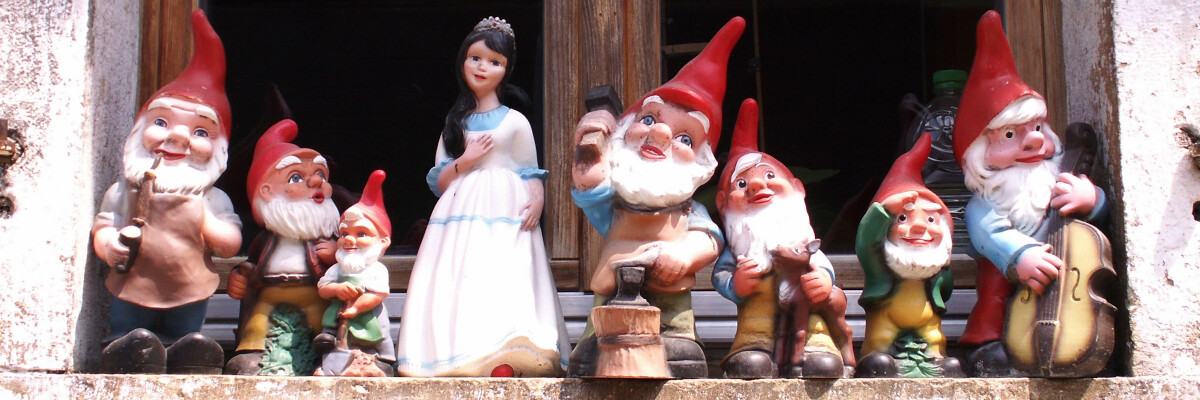 Statuette dei sette nani e di Biancaneve sul davanzale di una finestra