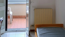 Il letto e la porta che conduce al balcone. Si nota il condizionatore.